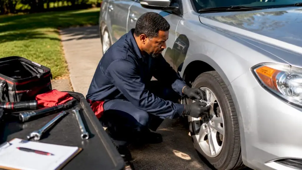 Mechanic inspecting car tire for safety