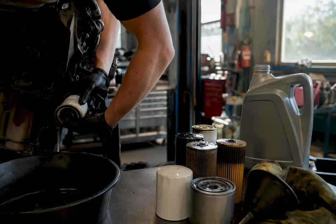 Hands removing oil filter during oil change