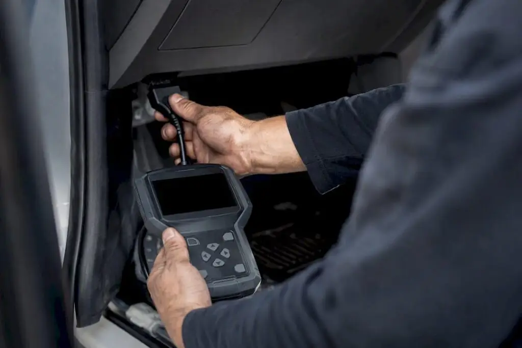 Technician using OBD-II scan tool in car
