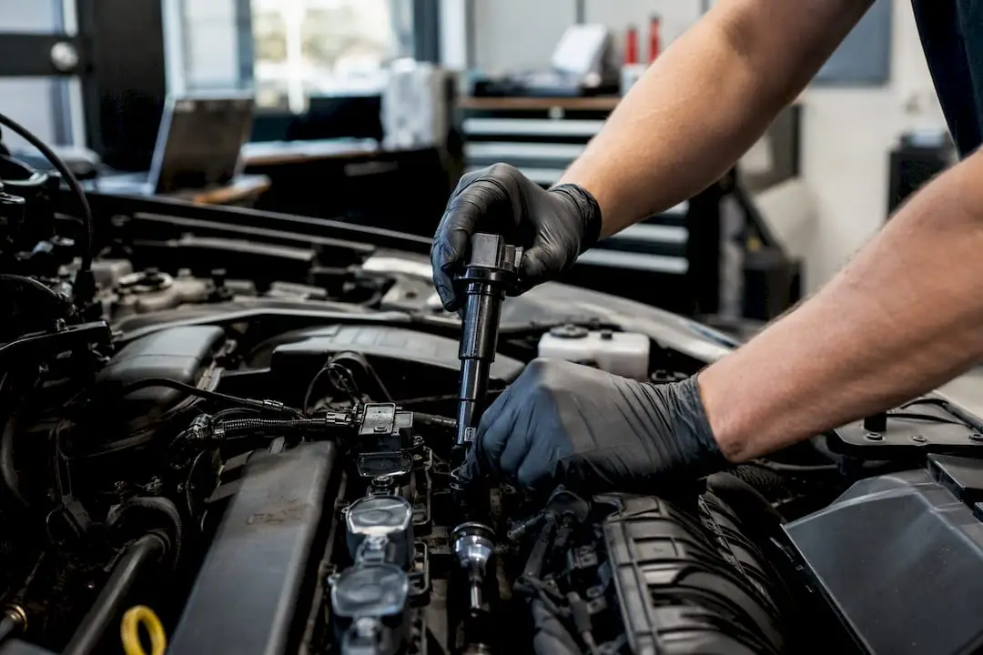 Hands swapping ignition coil in engine bay