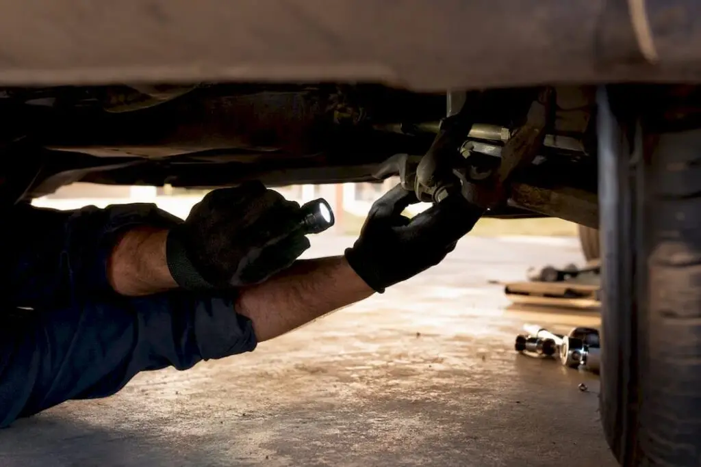 Technician inspecting fleet vehicle suspension