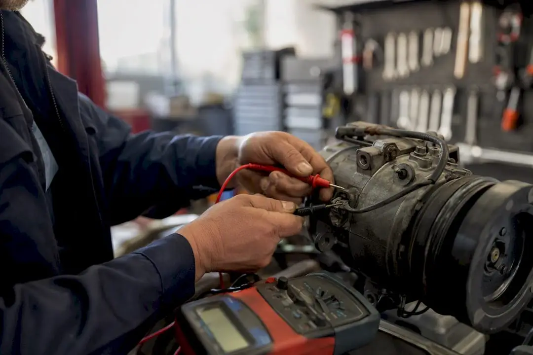 Technician testing AC clutch electrical connector
