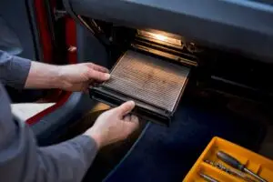 Hands replacing cabin air filter