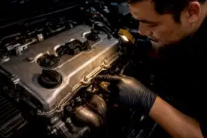 Technician inspecting valve cover gasket leak