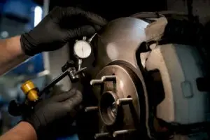 Technician measuring brake rotor runout