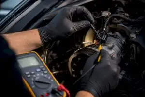 Technician testing AC clutch connector voltage