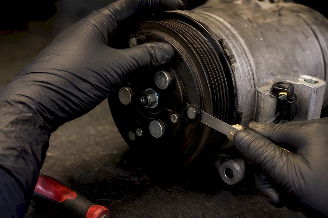 Technician measuring AC clutch air gap