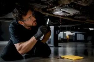Technician inspecting transmission fluid leak