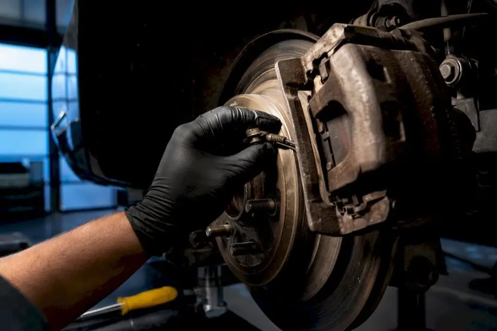 Technician inspecting a stuck parking brake mechanism