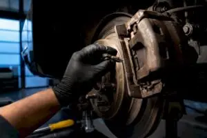 Technician inspecting a stuck parking brake mechanism