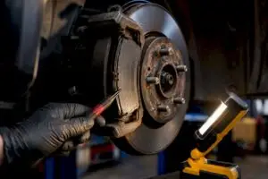 Worn brake pad beside rotor in service bay