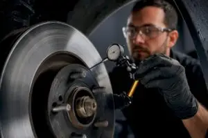 Technician inspecting brake rotor variation