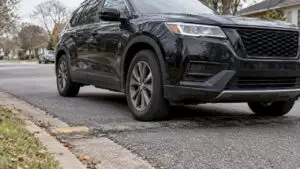 SUV crossing uneven pavement on neighborhood street