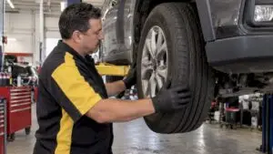 Technician checking an SUV tire in a repair bay